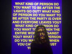 a person standing in front of a purple screen with words on it that read what kind of person do you want to be after the lights go out?