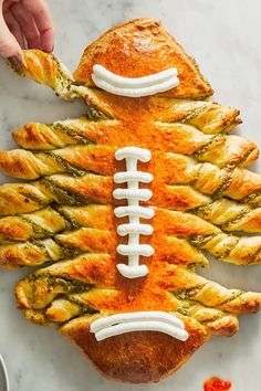 a football shaped pastry on top of a marble table with other food items around it