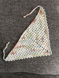 a piece of crocheted cloth with a string attached to it on a couch