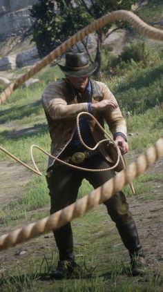 a man with a rope around his neck holding a whip on the ground in front of him