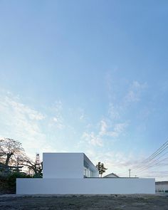 an empty white building sitting on the side of a road