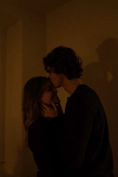 a man and woman standing next to each other in a room with shadows on the wall