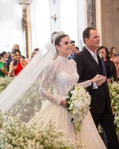 a bride and groom walking down the aisle at their wedding ceremony in an ornate church