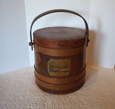 an old wooden box sitting on top of a white tablecloth covered floor next to a wall