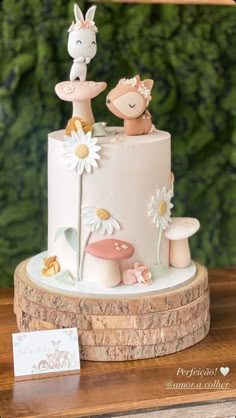 a cake decorated with animals and flowers on a table