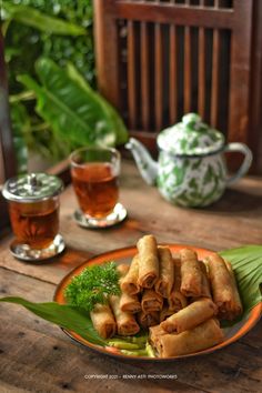 some food is sitting on a plate near a tea pot