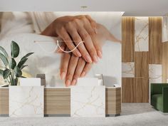 two hands touching each other in front of a wall with marble tiles and green chairs