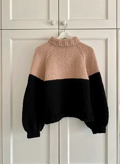 a sweater hanging on a hook in front of white cupboards