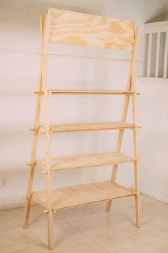 a wooden shelf sitting on top of a tiled floor next to a white stair case