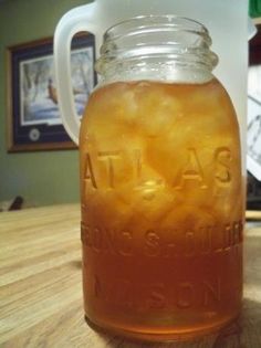 a glass jar filled with liquid sitting on top of a wooden table