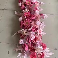 pink and white flowers are arranged on the floor