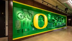 a large green sign that says o on it in front of a wall with bicycles