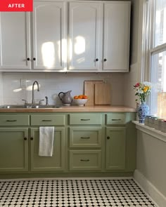 a kitchen with white cabinets and black and white tile flooring on the walls, along with a checkered rug