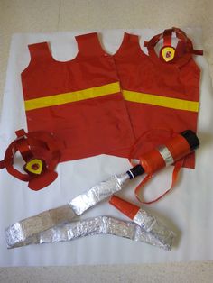 an orange fireman's vest and tools laid out on a white sheeted surface