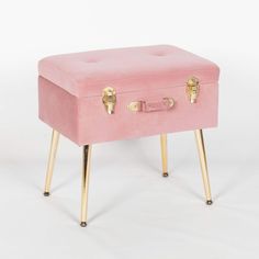 a pink stool with gold legs and a small box on it's legs,