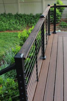 a wooden deck with black iron railings