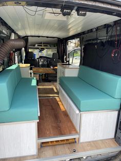 the inside of a van with couches and tables in it's rear end