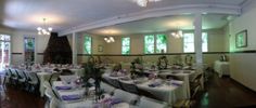 the dining room is set up for a formal function with white tablecloths and purple napkins