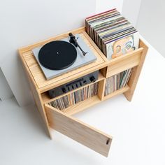 a record player is sitting on top of a shelf filled with cds and vinyl records