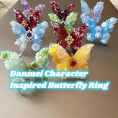 four different colored butterflies with the words danamie character inspired butterfly ring on it's side