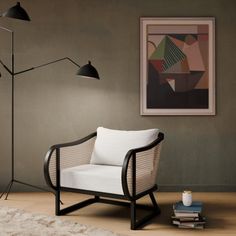 a living room with a chair, lamp and books on the floor in front of it