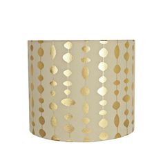 a lamp shade with gold foiled leaves hanging from the bottom, on a white background