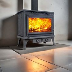 a stove that is sitting in the middle of a room with tile flooring on it