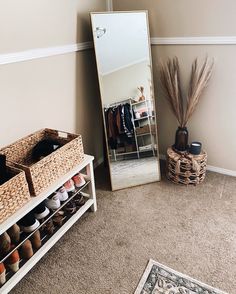 a room with a mirror, shoes and baskets on the floor