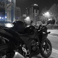 black and white photo of a motorcycle parked on the side of the road at night