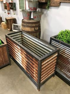 an old metal planter is sitting on the floor in front of some wooden barrels