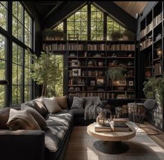 a living room filled with lots of furniture and bookshelves next to a window