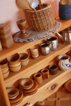 a shelf filled with lots of wooden bowls and cups