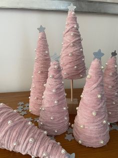 three pink christmas trees with silver stars on them