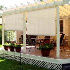 a covered patio with potted plants on the side and an awning over it