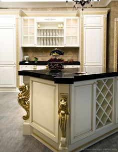 a fancy kitchen with white cabinets and black counter tops, an island in the middle