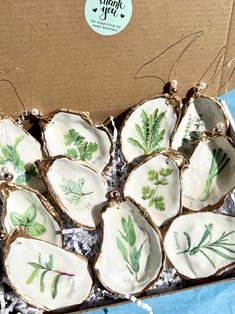 a box filled with white and green leafy cookies on top of a blue table cloth