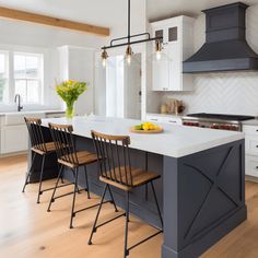 a kitchen with an island and chairs in it