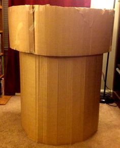 a cardboard box sitting on the floor in front of a bookshelf with a red curtain behind it