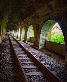 an old train track going through a tunnel