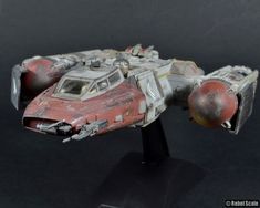 a toy model of a star wars vehicle on a black surface with no people around it