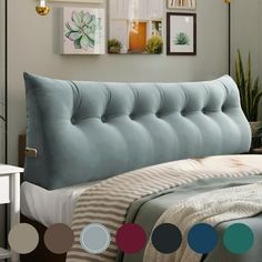 a bed with a blue tufted headboard and colorful circles on the wall above it