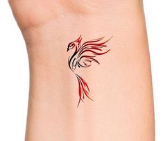 a red and black bird tattoo on the side of a woman's right arm