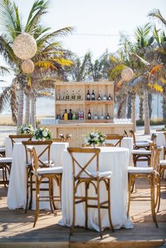 tables and chairs are set up for an outdoor event with palm trees in the background