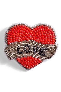 a red heart shaped brooch with the word love on it's side and beaded