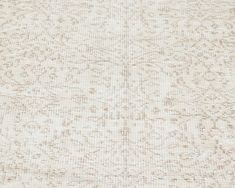 a white rug with brown spots on it