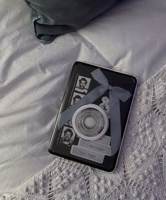 a black and white book laying on top of a bed next to an eyeglass case