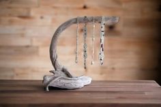 a piece of driftwood with beads hanging from it's end on a table