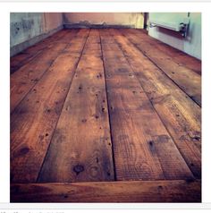 an empty room with wood floors and white walls