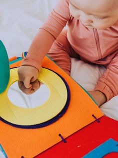 a toddler playing with a colorful play mat