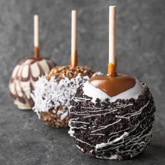 three chocolate covered desserts with candles on them